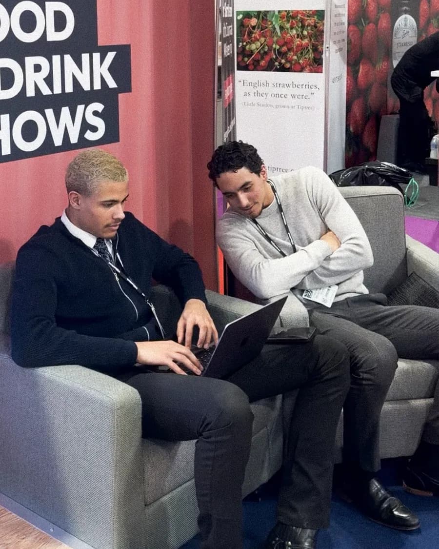 Two team members working on laptops at a trade show stand