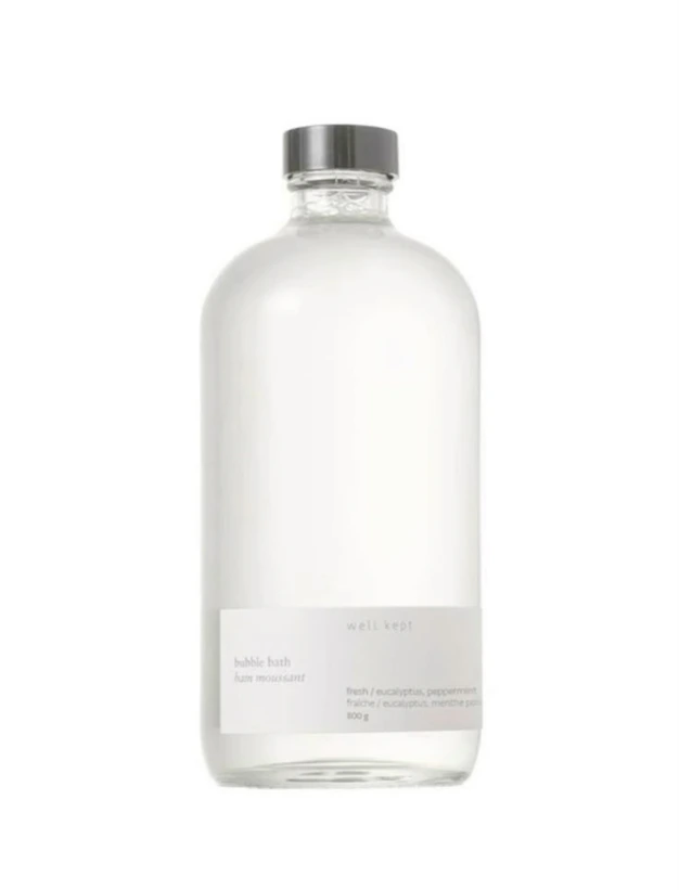 A clear glass bottle with a small label on white.