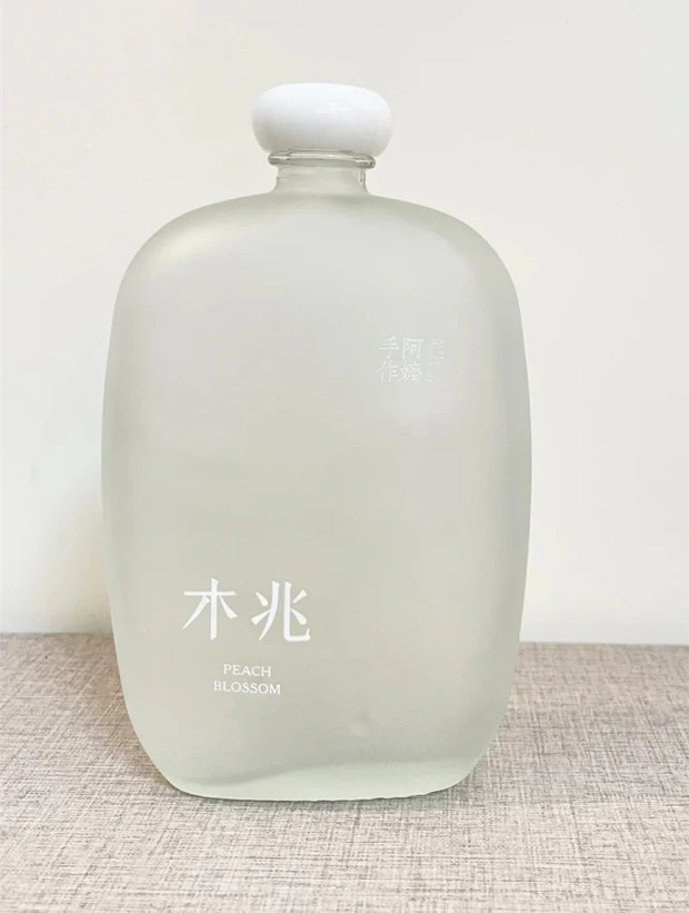 A frosted flask bottle with a white stopper.