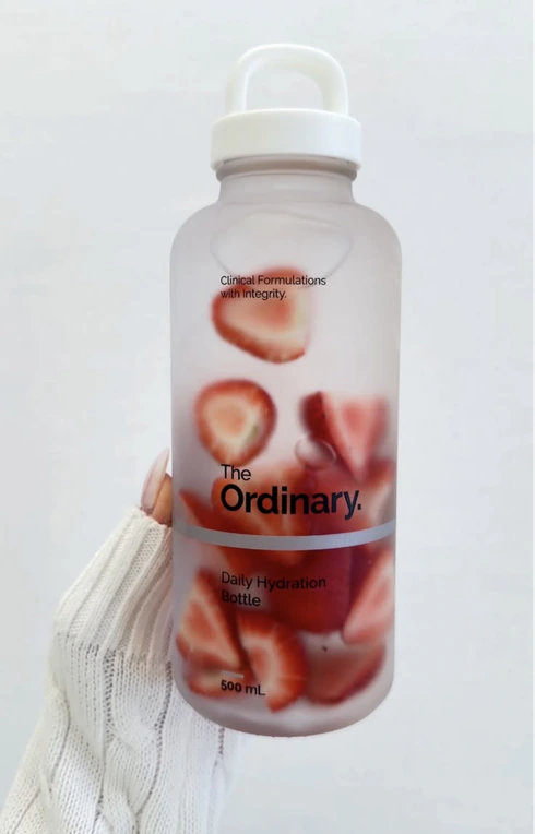 A frosted water bottle filled with strawberry slices.