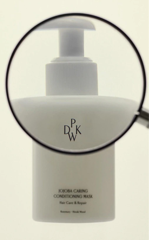 A white pump bottle under a magnifying glass.