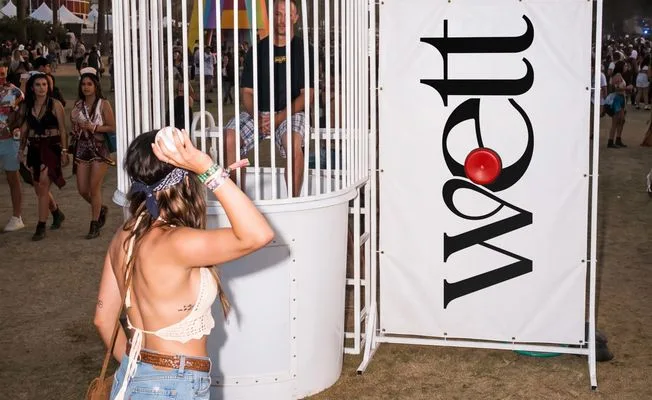 The Wett dunk tank at a festival, banner alongside.